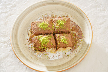cold baklava. Turkish delight desserts. baklava dessert in a light plate with a glass of tea on a light background
