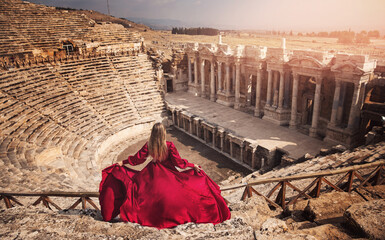 Hierapolis ancient city Pamukkale Turkey, woman in red dress background ruins Unesco sunset