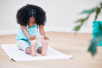 Treat your body well and it will reward you. Shot of a young girl practicing yoga at home.