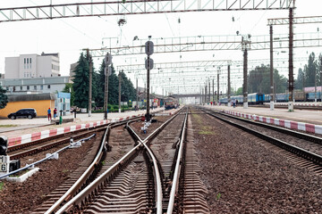 Fototapeta premium Railway station with rails, buildings and trains in the distance