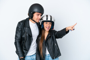 Young caucasian couple with a motorcycle helmet isolated on white background pointing to the side to present a product