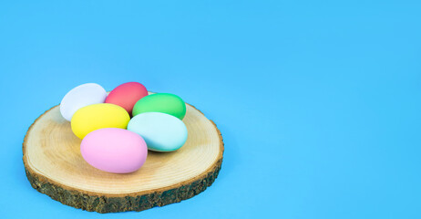Fototapeta na wymiar Easter, plain, multi-colored eggs on a hemp plate on a blue background. Banner .The concept of holiday, religion, customs, egg coloring . High quality photo