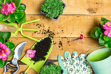 Garden tools and spring flowers on a wooden table