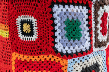Colorful crochet knit on a tree trunk yarn bombing. Patchwork knitted crochet covered tree for...