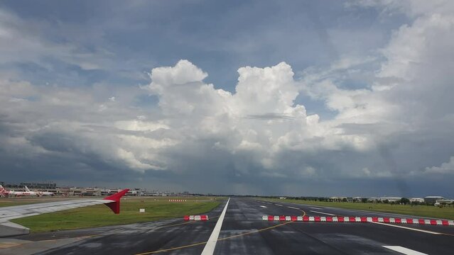 Plane landing at airport runway with couldy rainy weather far away landscape