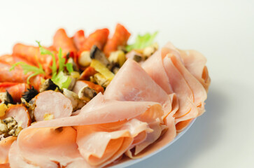 A cold plate prepared for the party with sliced chorizo, ham and sausages