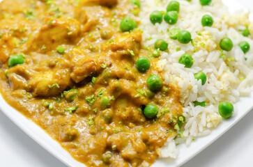 Chicken curry with egg fried rice, chicken breast pieces in a mildly spiced coconut curry sauce with fried rice with peas and egg