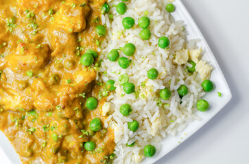 Chicken curry with egg fried rice, chicken breast pieces in a mildly spiced coconut curry sauce with fried rice with peas and egg