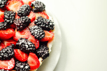 Butter enriched shortcrust pastry topped strawberries and blackberries, seasonal cake with colorful decoration