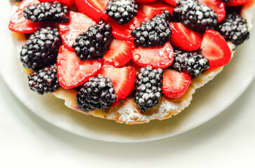 Butter enriched shortcrust pastry topped strawberries and blackberries, seasonal cake with colorful decoration