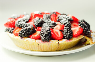 Butter enriched shortcrust pastry topped strawberries and blackberries, seasonal cake with colorful decoration