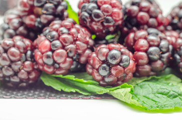 Closeup of a set of blackberries with mint, fresh and ripe forest fruits