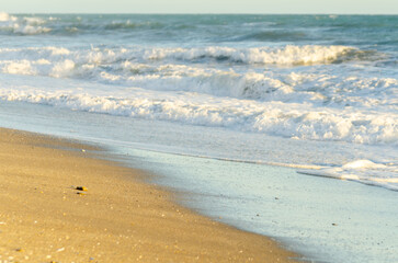 View on the seawater affecting the sand on the beach, sea waves flowing  calmly at the sand
