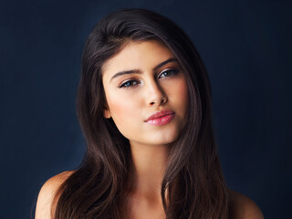 Naklejka premium Shes the picture of beauty. Cropped portrait of a gorgeous young woman posing against a dark background.