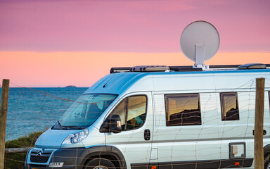 Caravan by sea with satellite dish on roof