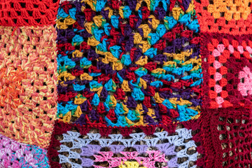 Colorful crochet knit on a tree trunk yarn bombing. Patchwork knitted crochet covered tree for...