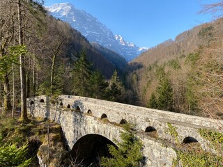 Old stone bridge over the river L&ouml;ntsch and over the canyon L&ouml;ntschtobel at the foot of the alpine reservoir Kl&ouml;ntalersee (or Kloentalersee) - Canton of Glarus, Switzerland (Schweiz)