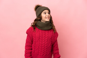Little girl with winter hat isolated on pink background with surprise facial expression