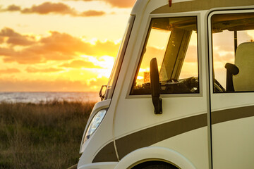 Camper on beach at sunset