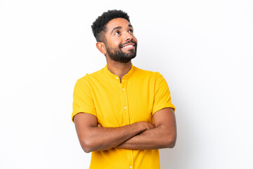 Young Brazilian man isolated on white background looking up while smiling