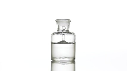 Grey drop is falling into old fashioned bottle with grey clear liquid on white background | Abstract skin care cosmetics with hyaluronic acid formulating concept