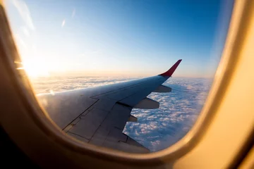 Foto auf Acrylglas Flugzeug Den Sonnenuntergang durch das Flugzeugfenster betrachten