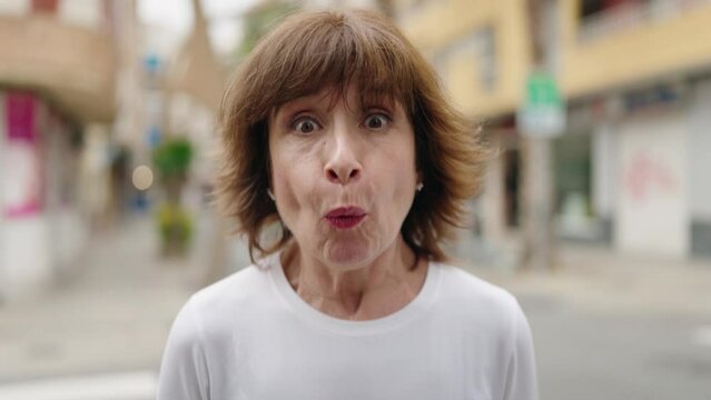 Middle age woman smiling confident surprised screaming at street