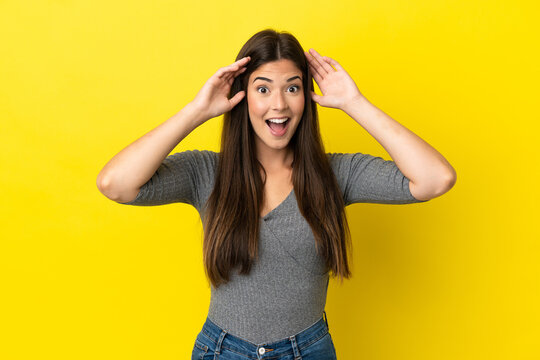 Young Brazilian woman isolated on yellow background with surprise expression