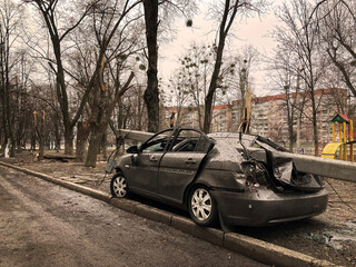 Obraz na płótnie Canvas A damaged car in Kharkov as a result of shelling of a peaceful city by Russian troops. Bombing of residential buildings by Russian assassins.