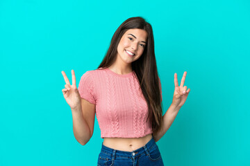 Young Brazilian woman isolated on blue background showing victory sign with both hands