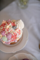 Festive Easter cakes with white icing and sugar decor on a table decorated in spring style