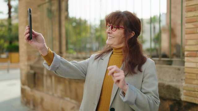 Middle age woman business executive make selfie by the smartphone at street