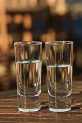 Two glasses with fresh still water outdoors in the summer evening. 
