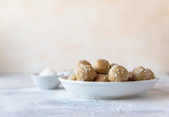 Chickpea and peanut butter candies sprinkled with coconut chips. Energy balls. Healthy raw dessert without sugar. Vegan truffles.