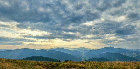 Panorama from the top of Mount Bozova in Transcarpathia, Ukraine. Summer evening in the Carpathian mountains. Beautiful cloudy sky over the villages of the valley