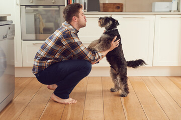 Life is good with a faithful friend by your side. Shot of a man playing with his dog at home.