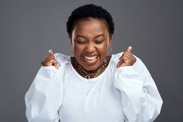 My application was accepted. Shot of a beautiful young woman looking excited while posing against a grey background.