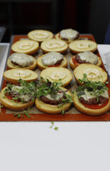 bandeja de hamburguesas con carne y queso fundido para catering con sus ingredientes