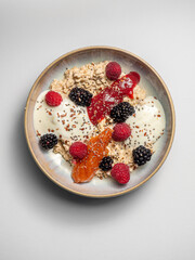Breakfast - Oatmeal overnight with jam, raspberries, blackberries, chia seeds, yoghurt. On a ceramic plate, with a white  background