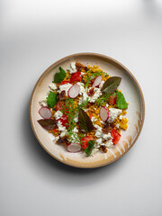 Couscous salad with  cheese. On a ceramic plate, with a white background