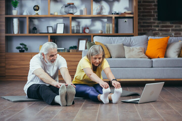 Senior couple, man and woman doing morning exercises together, doing fitness sitting on the floor,...