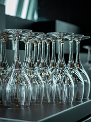 A lot of empty wine glasses in a row on the table in the restaurant. 