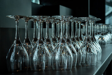 A lot of empty wine glasses in a row on the table in the restaurant. 