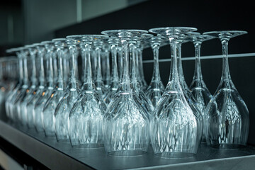 A lot of empty wine glasses in a row on the table in the restaurant. 