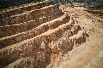 Sand and gravel open pit mining. Ledges of open pit sand quarry top down aerial view. Terraces of...