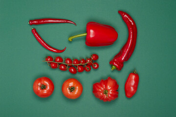 grouped vegetables with red peppers, pepperoni and tomatoes on a green background