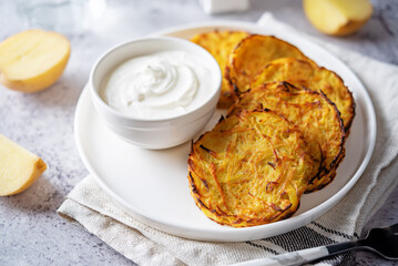 Potato hash browns with sour cream sauce in a plate