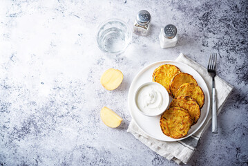 Potato hash browns with sour cream sauce in a plate
