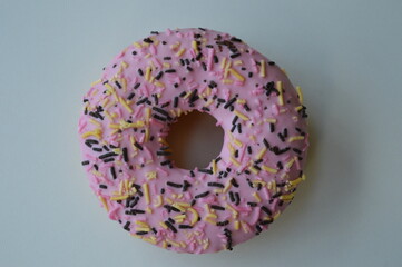 Delicious donut topped with pink sugar topping on a white background