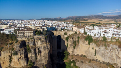 Fototapeta na wymiar Aerial drone view of The Puente Nuevo, New Bridge in Ronda. White villages in the province of Malaga, Andalusia, Spain. Beautiful village on the cliff of the mountain. Touristic destination. Holidays.